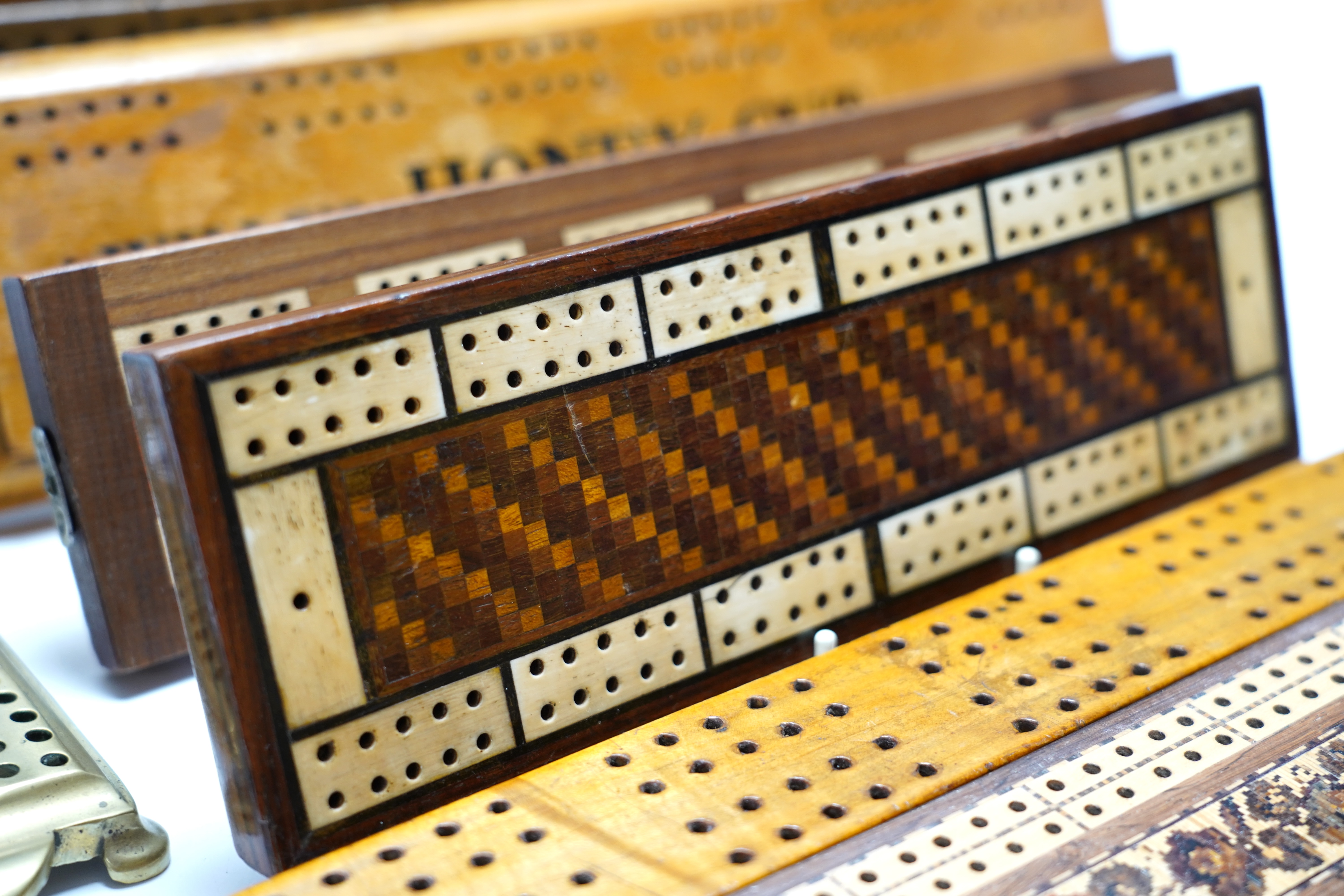 Nine cribbage boards including a horn example, 'Wills Tobacco' advertising and bone and marquetry examples, largest 42cm in length